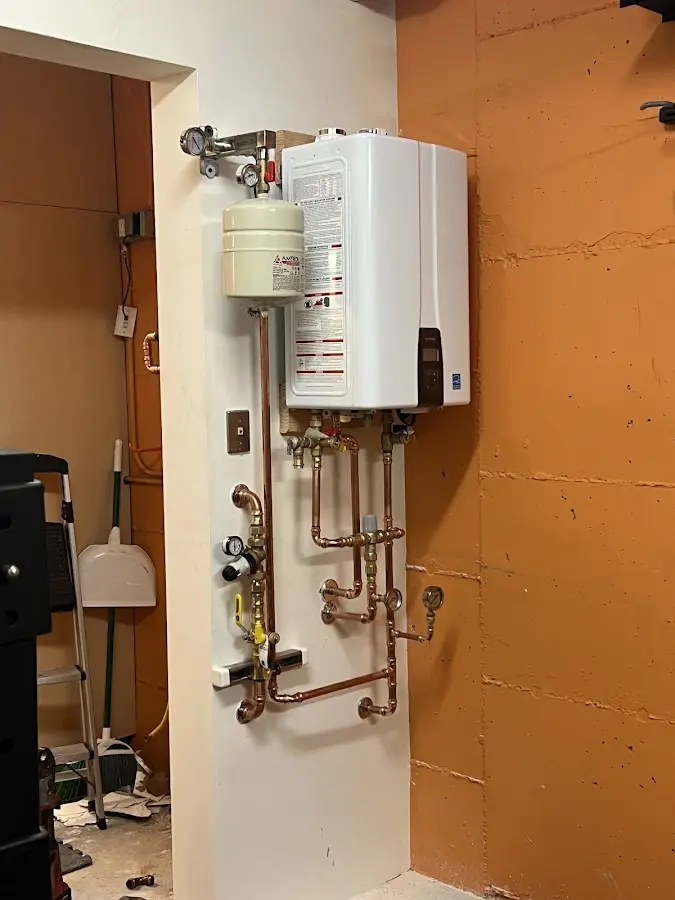 Plumbing technician inspecting water heater connections in Fredericksburg